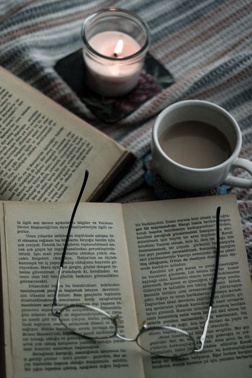 Un libro abierto junto a una taza de café